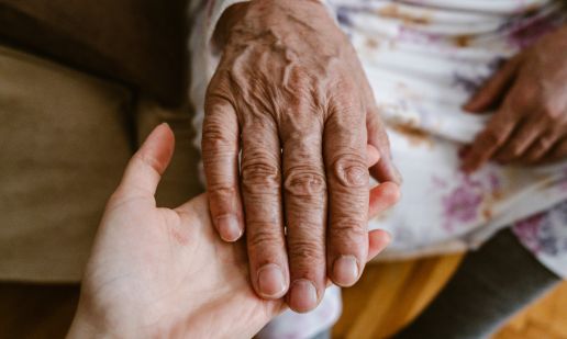 Une main tenant celle d'une personne âgée, symbole de l'accompagnement à domicile